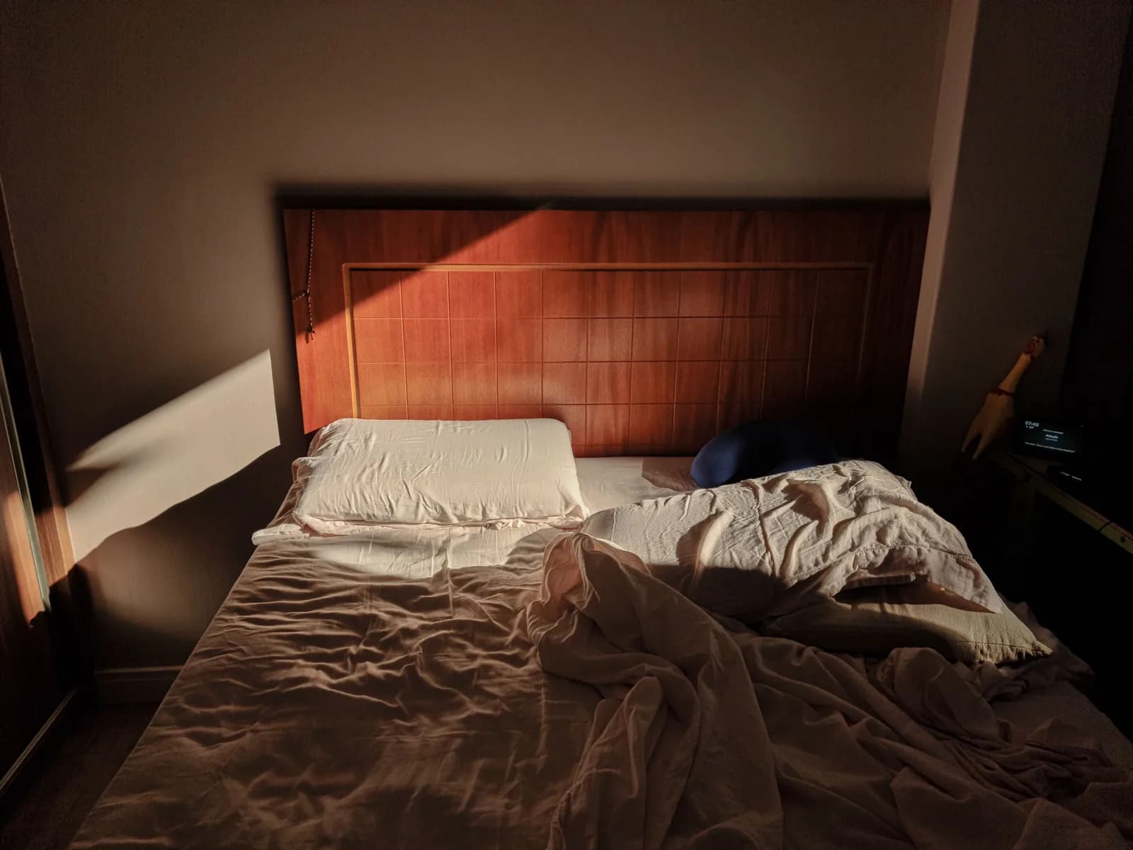 Cama desfeita com toalhas dobradas ao lado, no dia do check-out